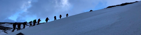 A group of people hiking up a snowy hill